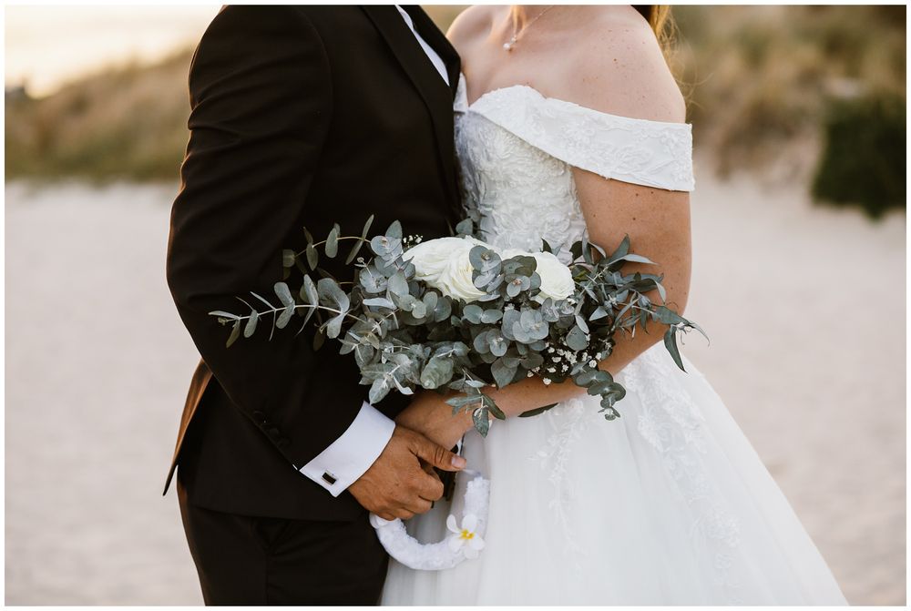 bride holding her bouquet at city beach bridal shoot