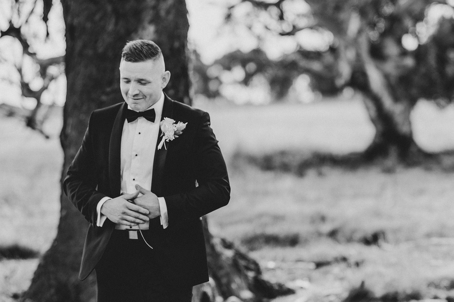 A black and white portrait showing elegant formal attire against a rustic backdrop.
