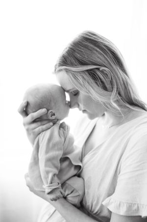 Black and white portrait of tender moment between parent and infant.