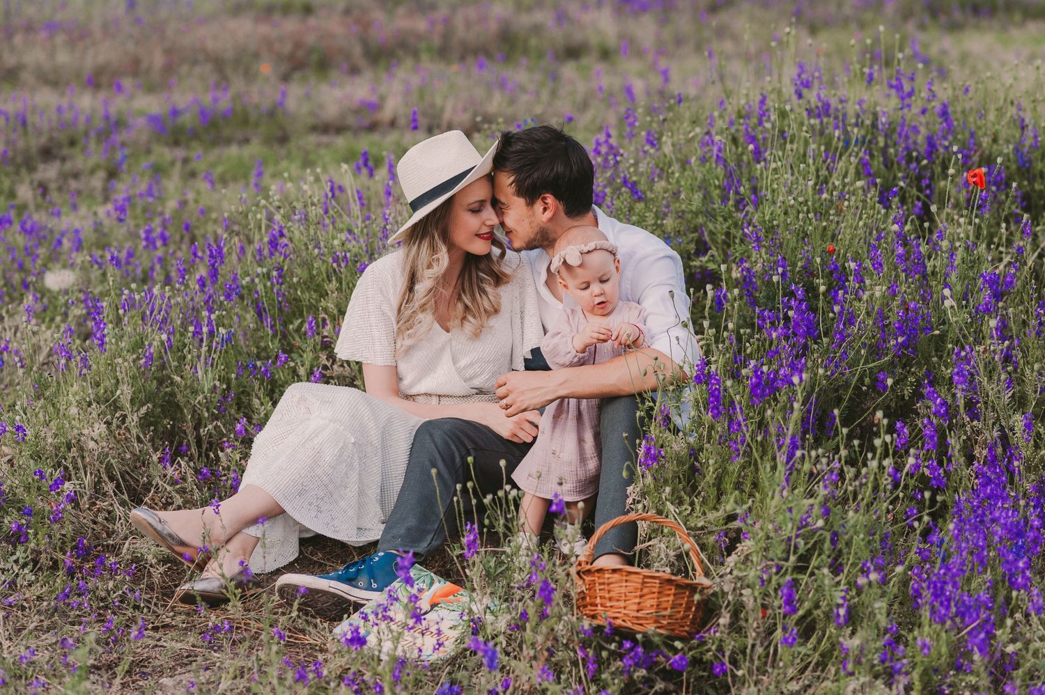 A romantic scene unfolds in a meadow filled with purple wildflowers and red poppies.