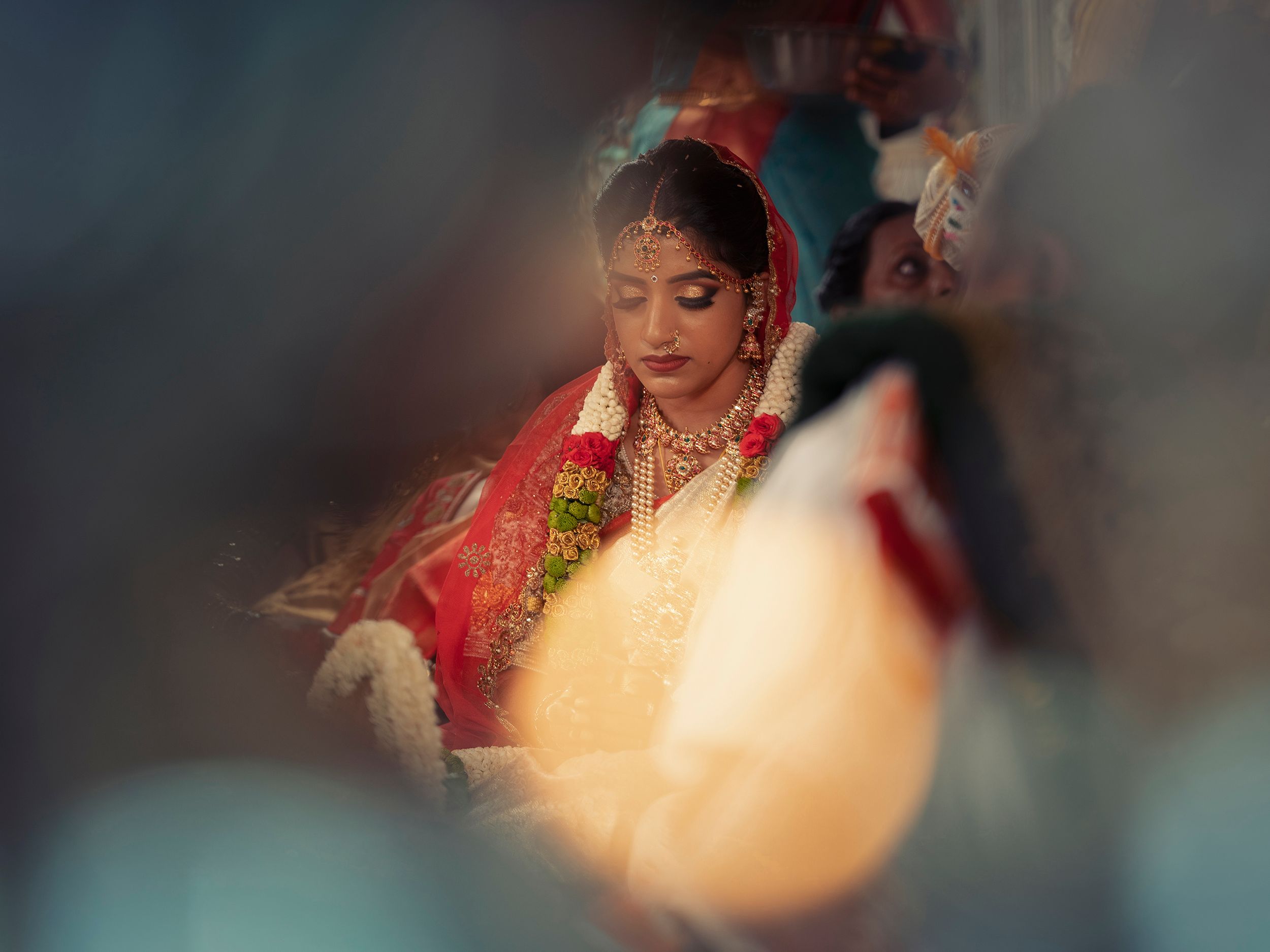 A soft focus image of a bride in traditional red Indian wedding attire.