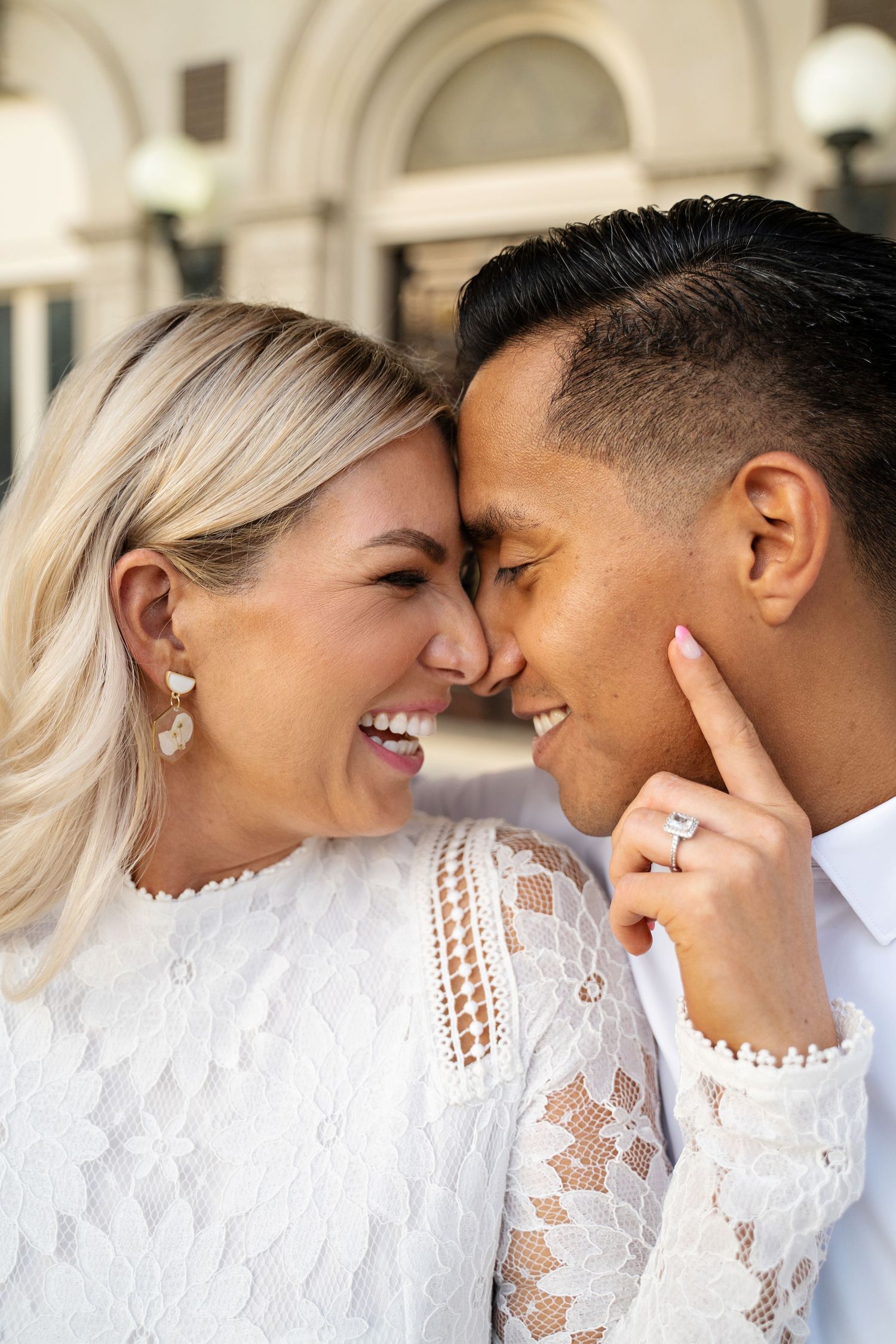 Couple laughing in up close pose touching foreheads and eyes closed