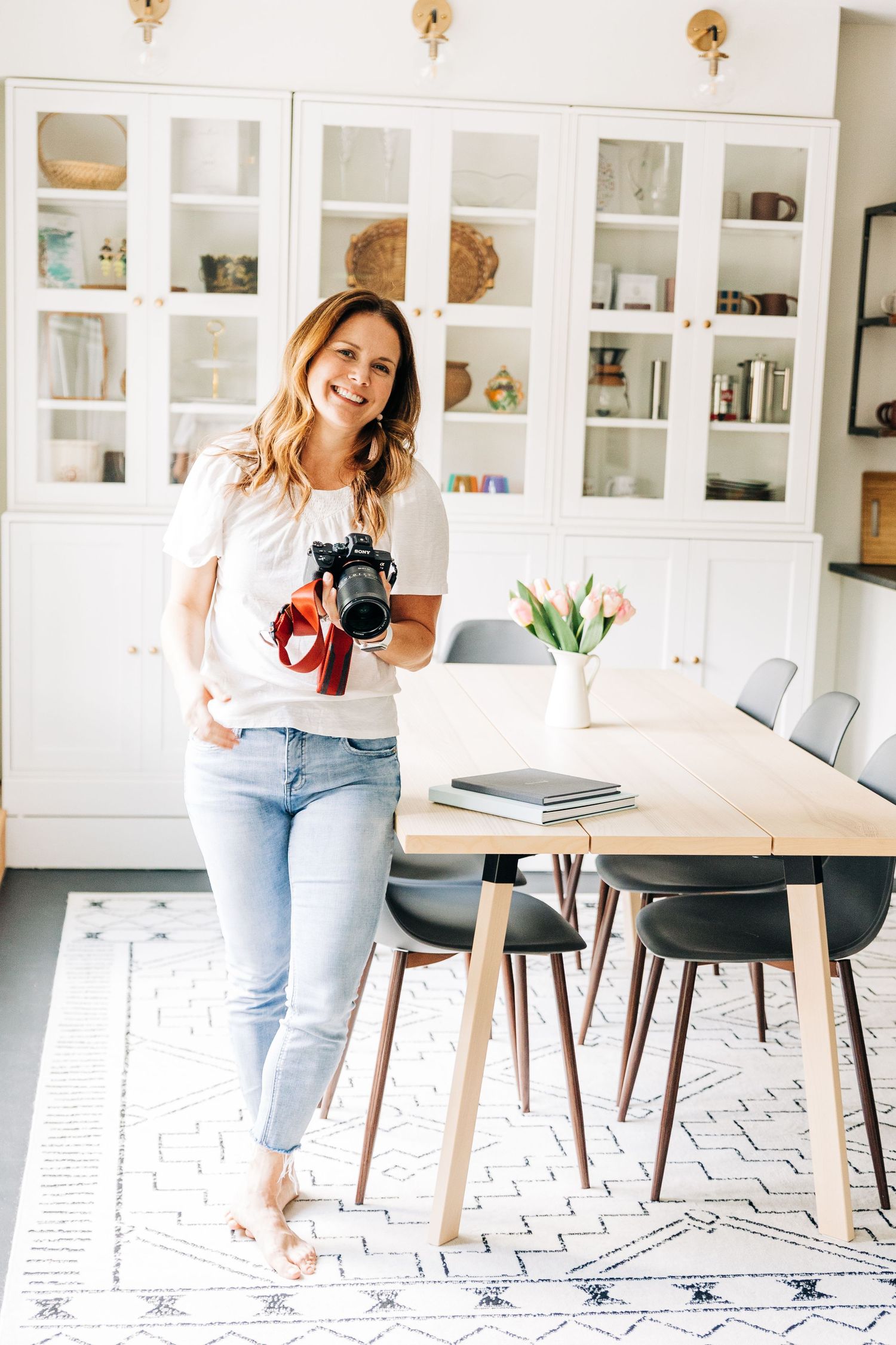 Brightly lit room of photographer holding her camera at Little Villa Charlotte