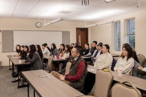 Wide view of a professional development session with attendees seated at long tables.
