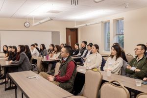 Meeting attendees listening attentively in a corporate training room with projection screen.