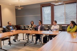 Spacious conference room with wooden panels and multiple seating arrangements.