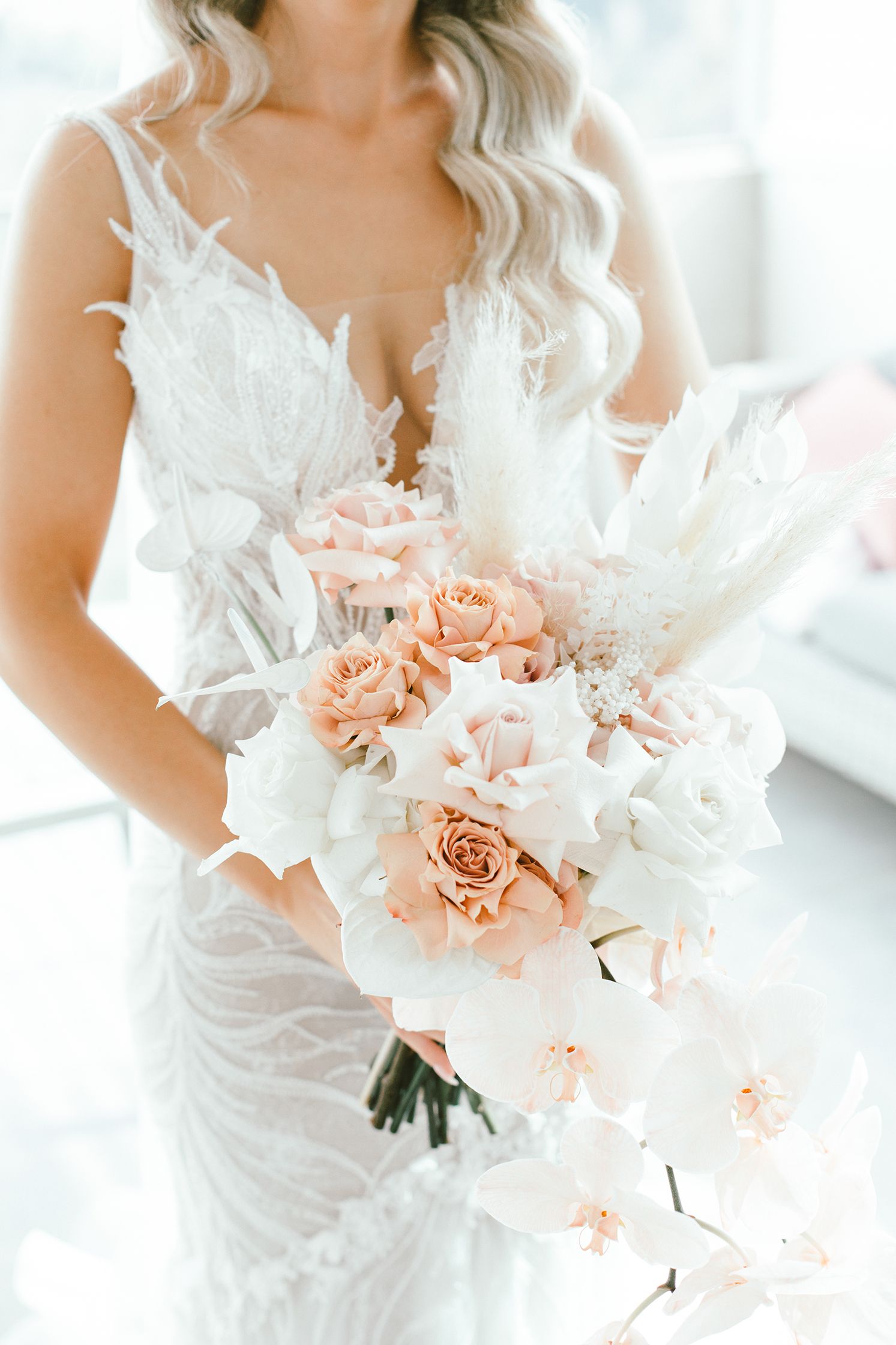 Elegant bridal bouquet featuring peach roses and white floral accents.