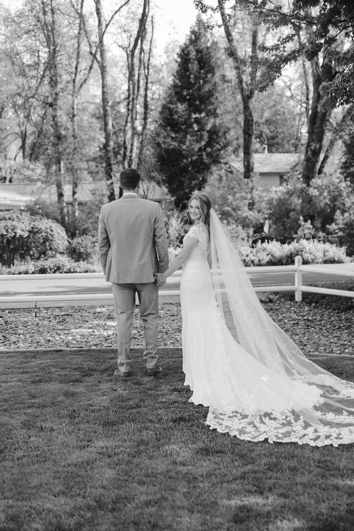 Black and white wedding photo showcasing the bride's dramatic lace-trimmed cathedral veil.