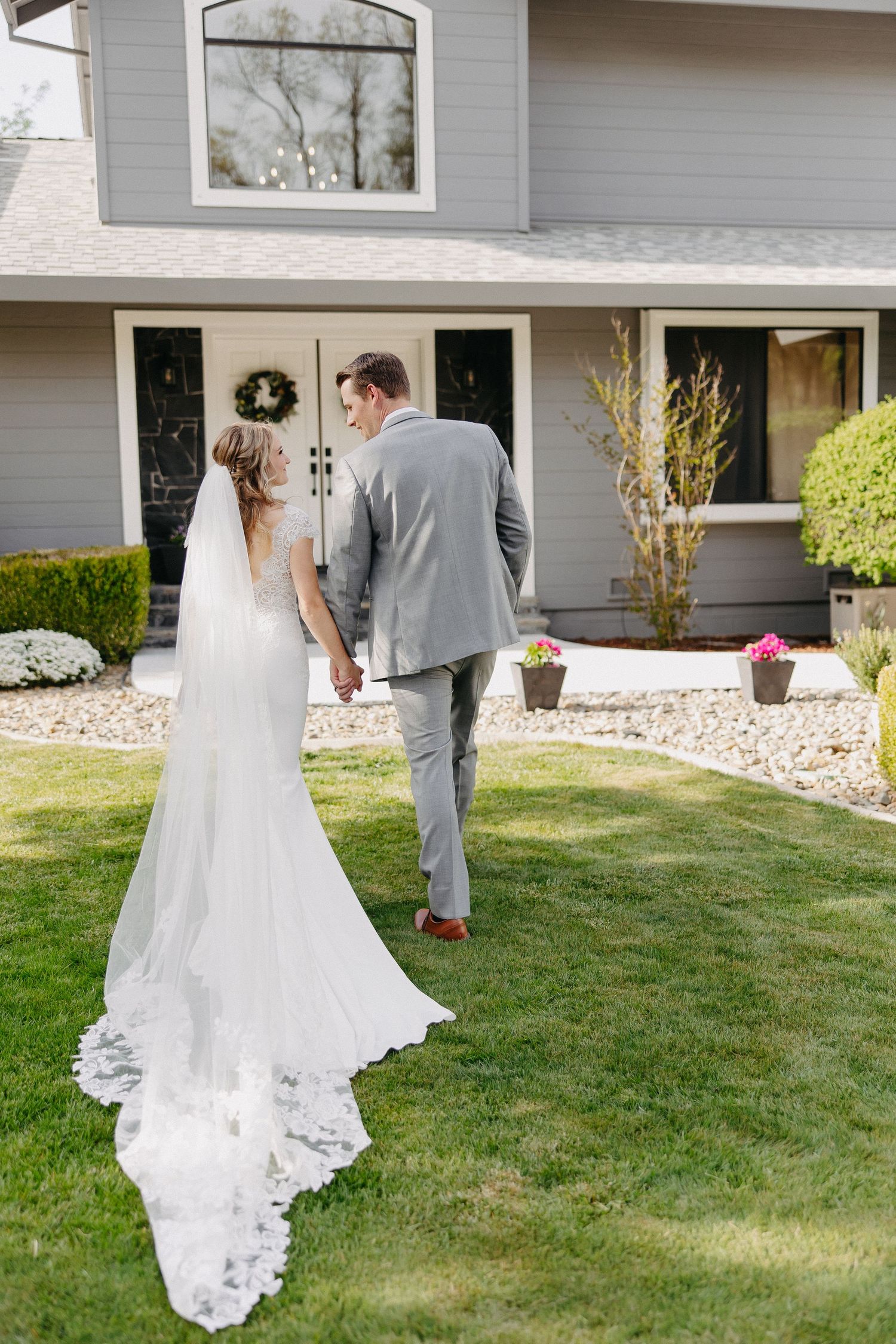 Wedding couple shares an intimate moment on their special day in front of their home.