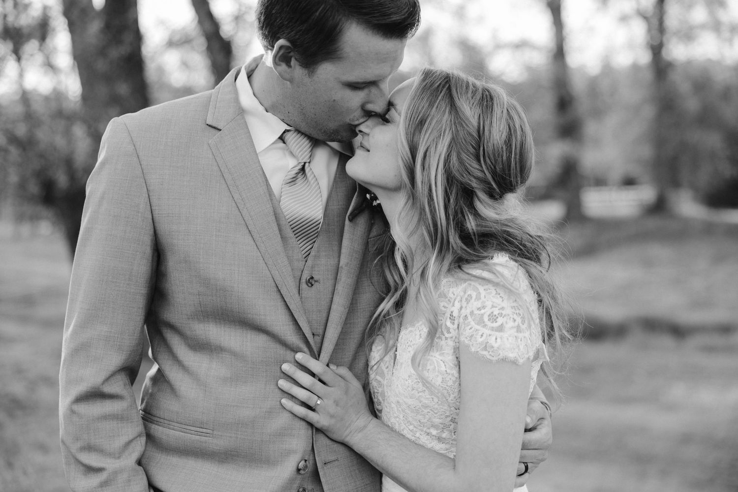 Black and white intimate portrait of newlyweds sharing a tender moment.