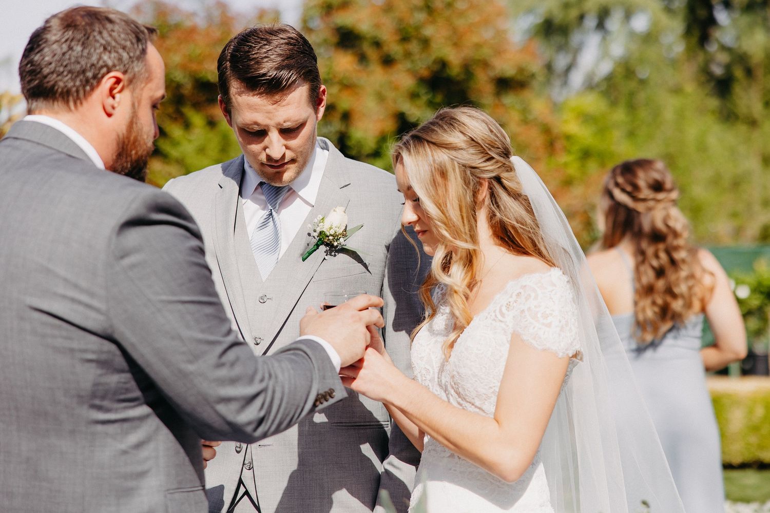 Wedding ceremony in progress as couple exchanges vows in outdoor garden setting.