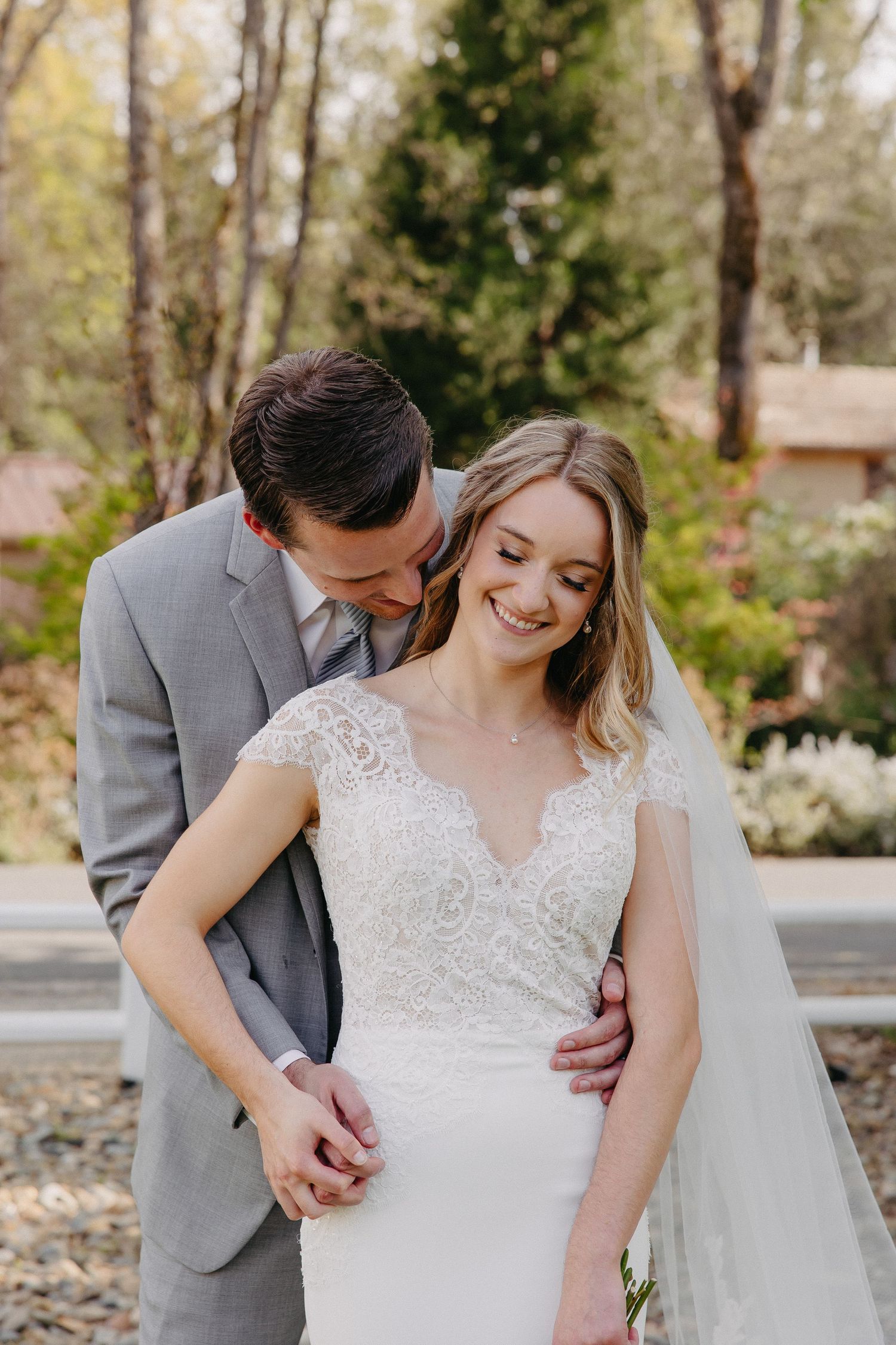 A tender moment between newlyweds in a garden as they share an intimate embrace.