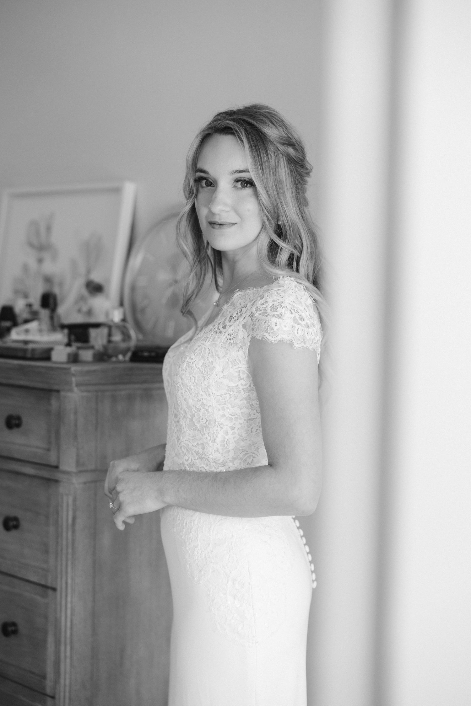 An elegant black and white portrait in a lace-detailed wedding dress.