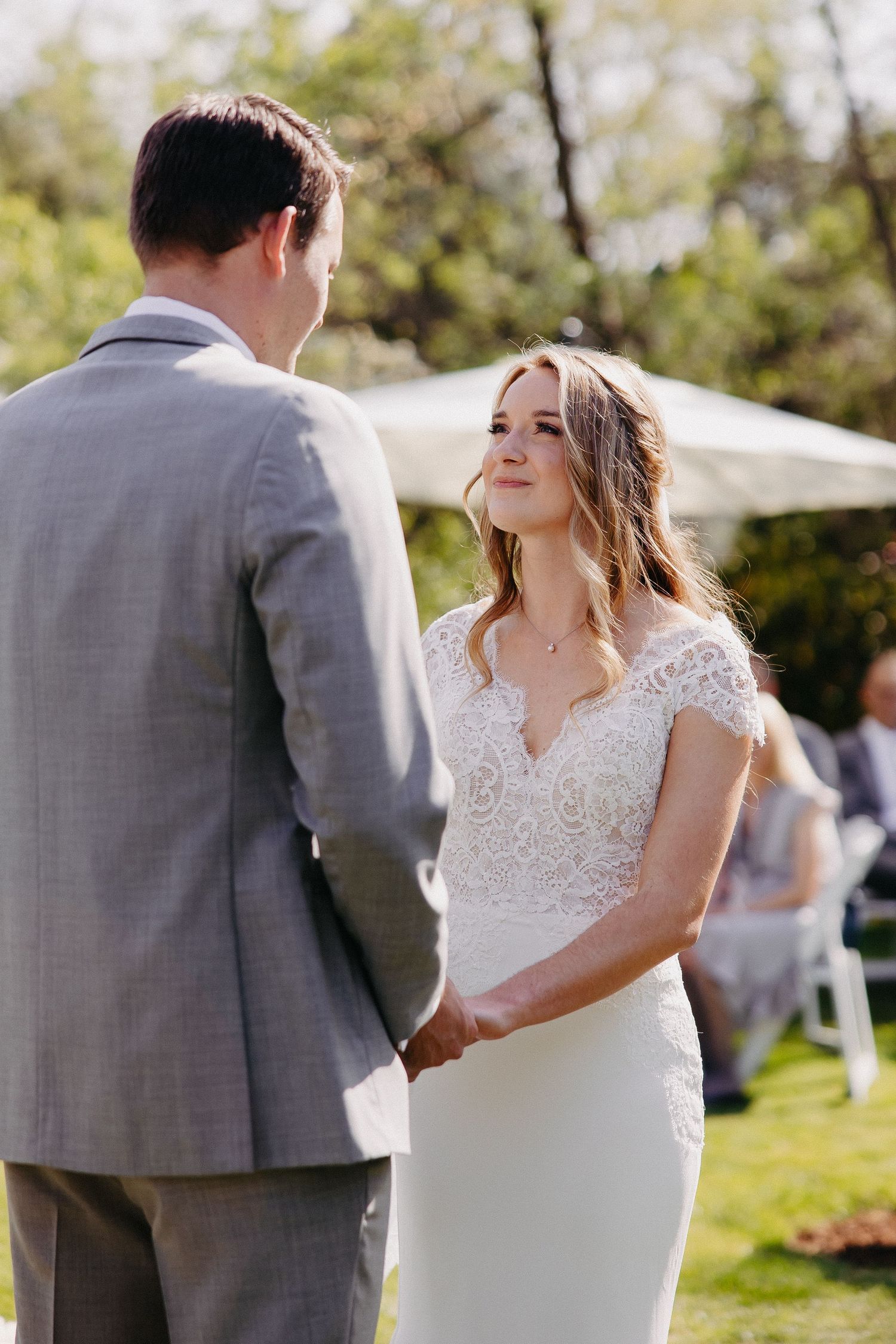 Intimate moment between couple during outdoor wedding ceremony with natural lighting.