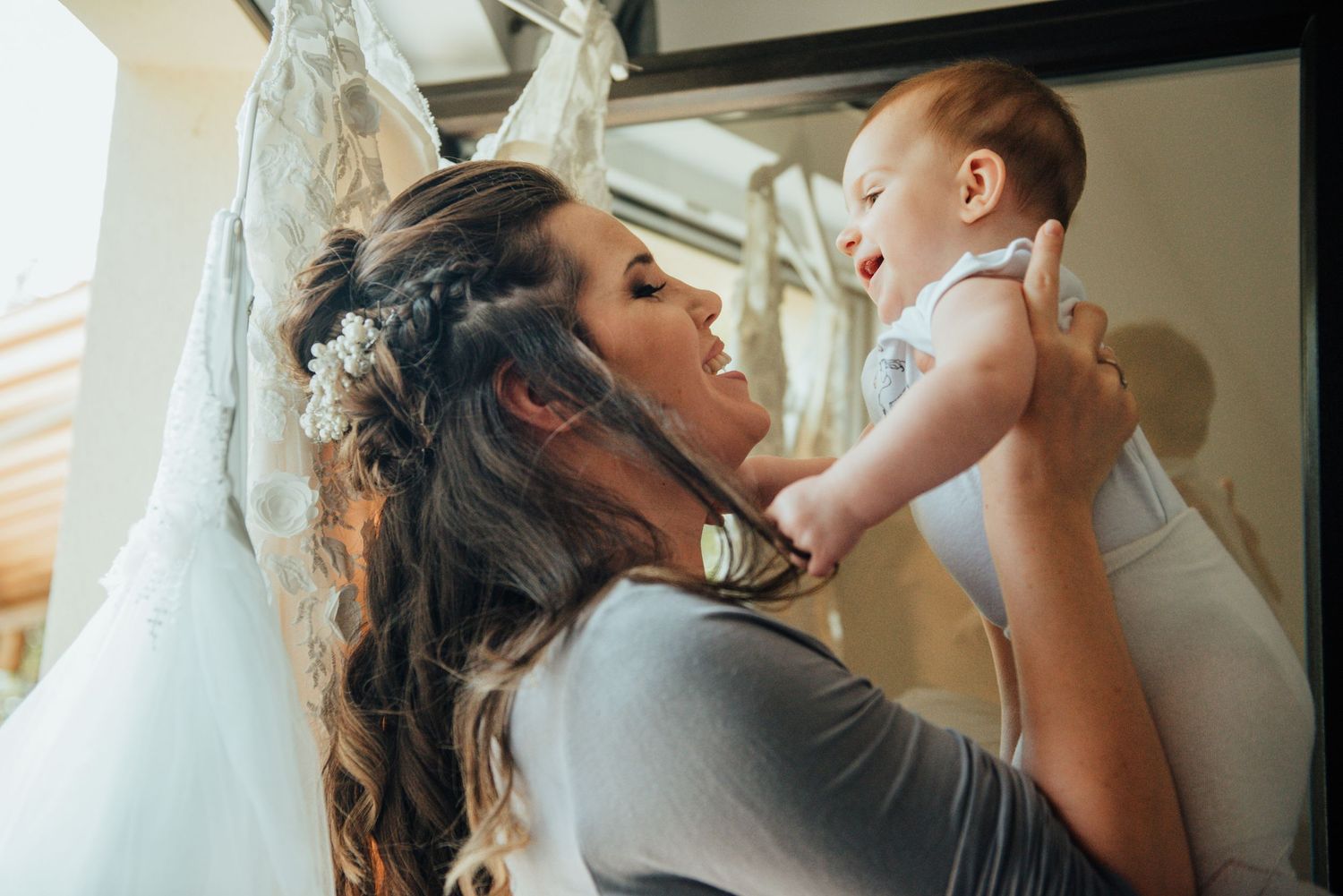 A tender moment between a parent and baby while getting ready for a special occasion.