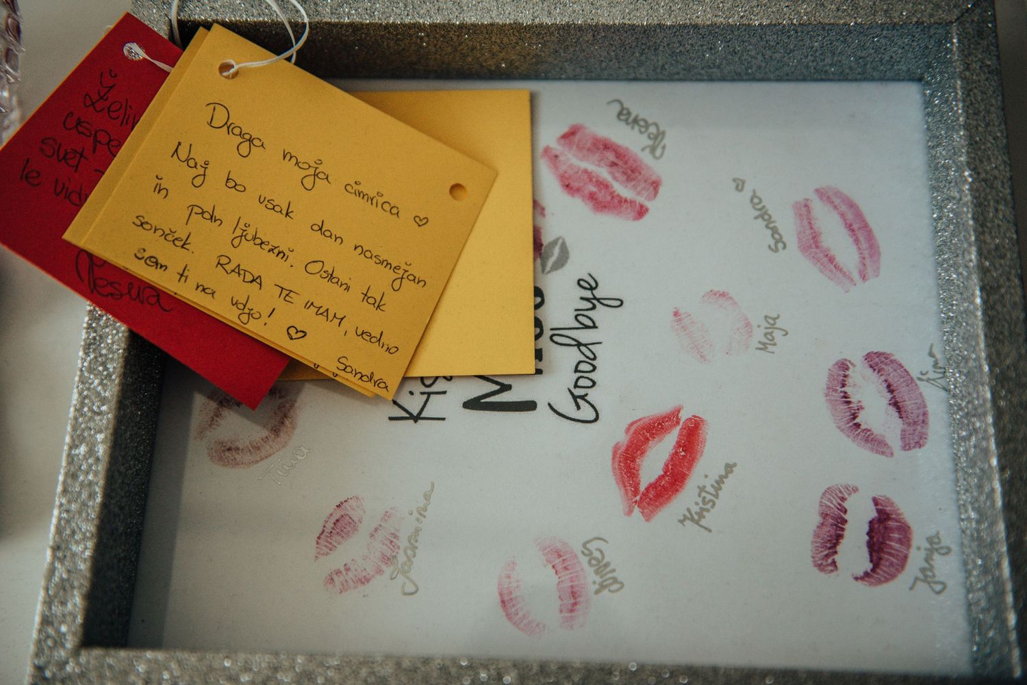 A collection of lipstick kiss prints on paper with a handwritten note attached.
