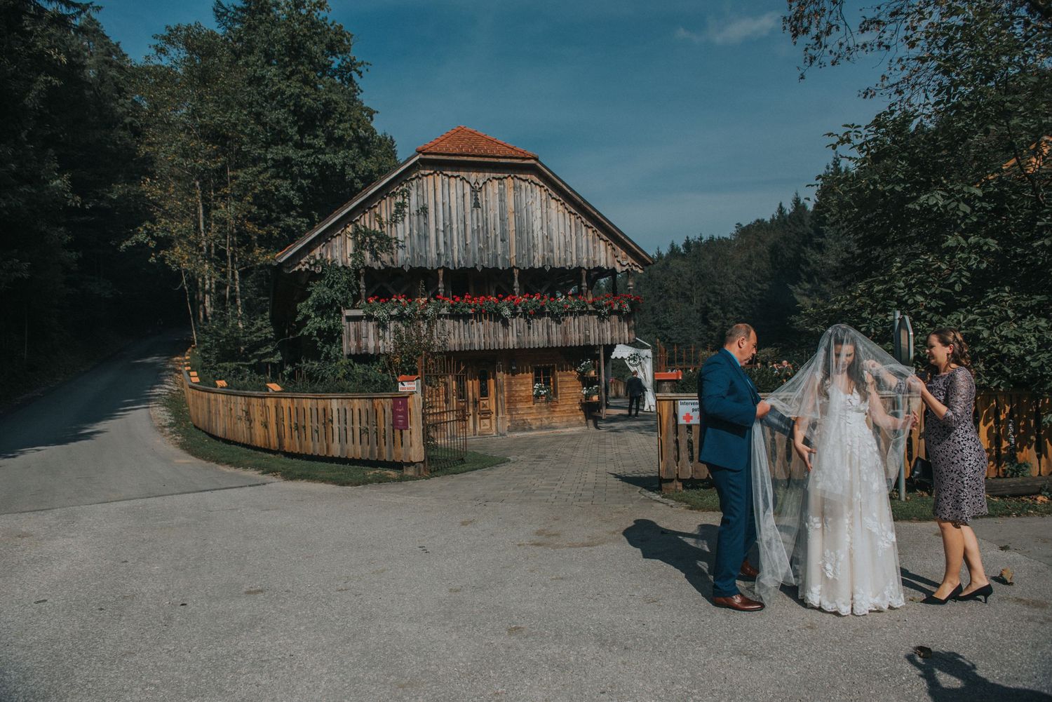 A rustic barn wedding venue with wooden architecture and a stone pathway.