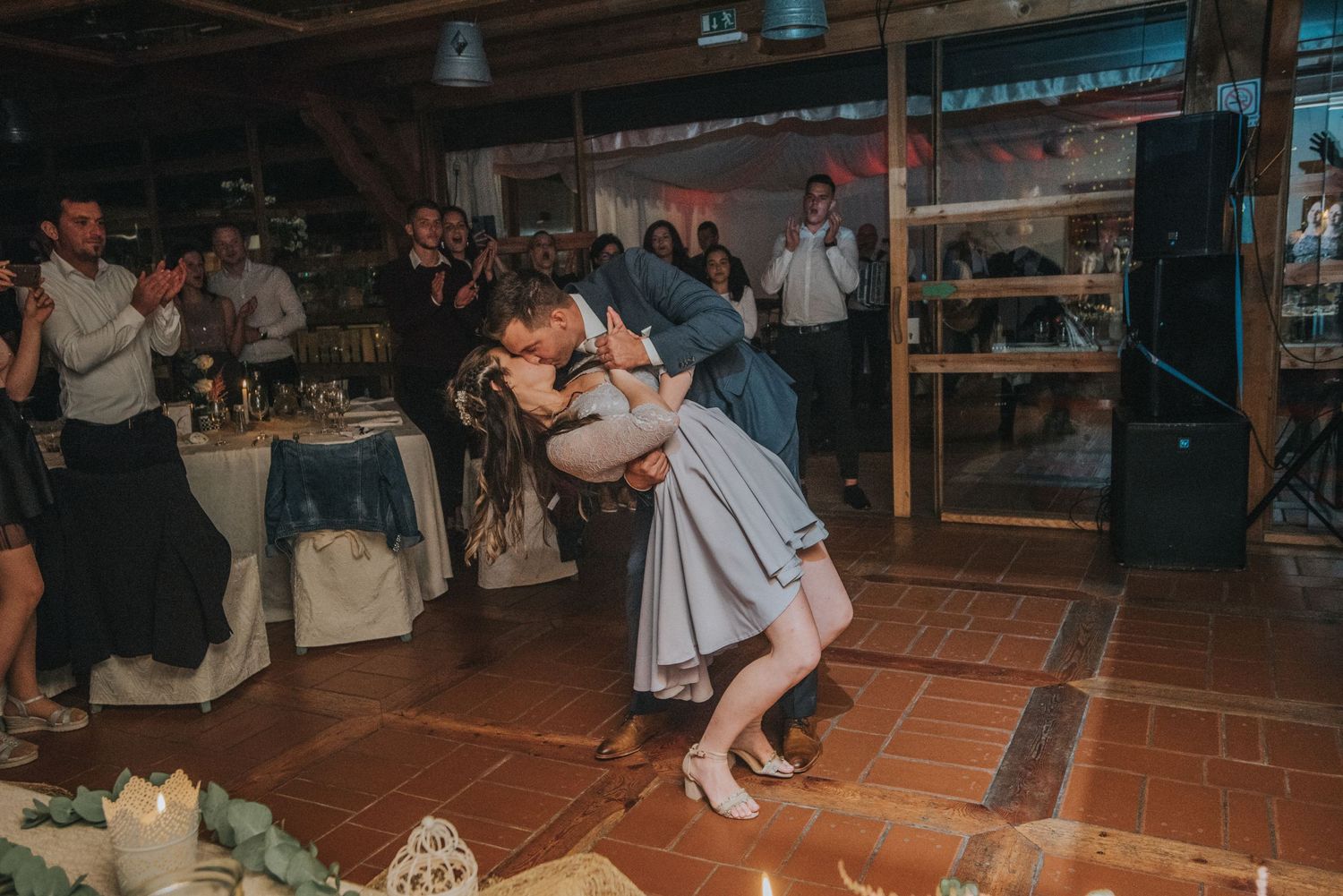 Romantic dance moment at wedding reception on terracotta tile floor.