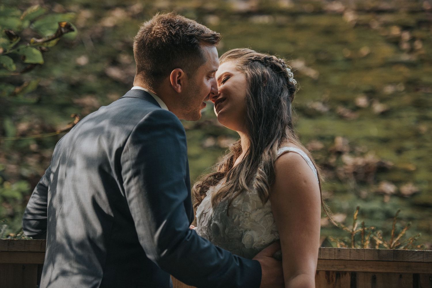 A candid wedding moment captured outdoors with natural autumn scenery in the background.