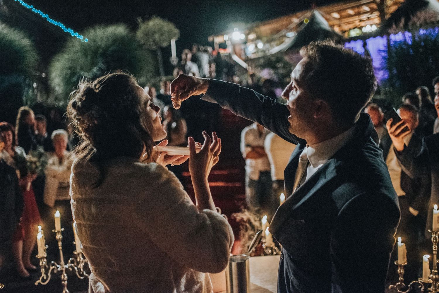Romantic moment between couple at candlelit wedding celebration.