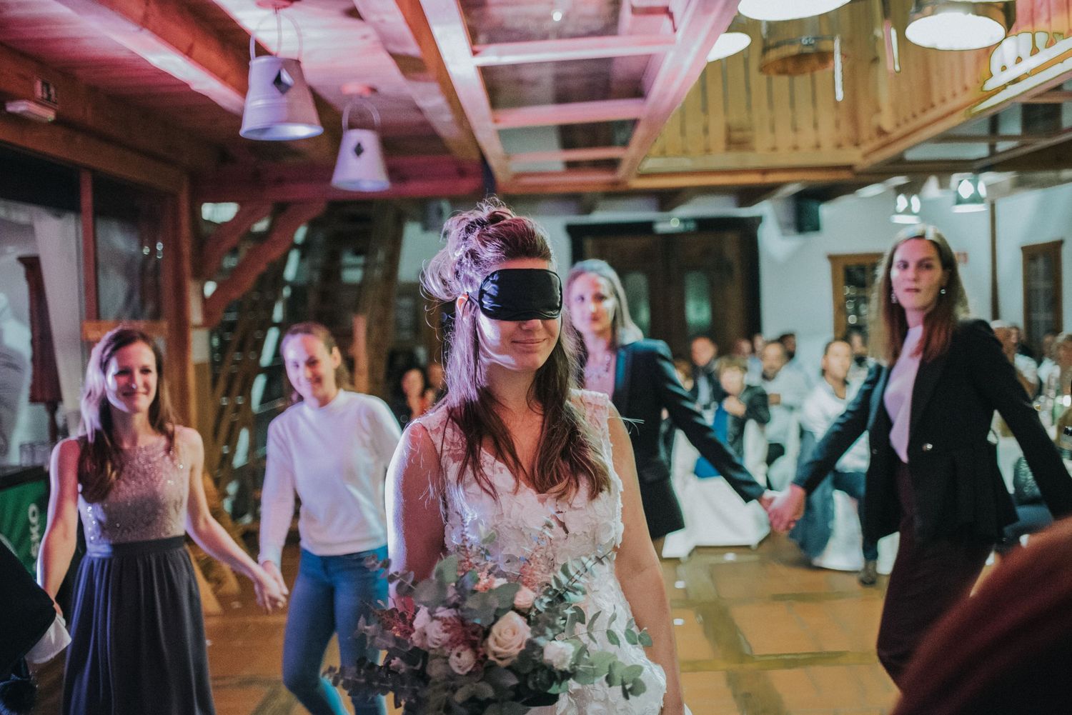 Wedding reception dancing scene with guests in indoor venue.