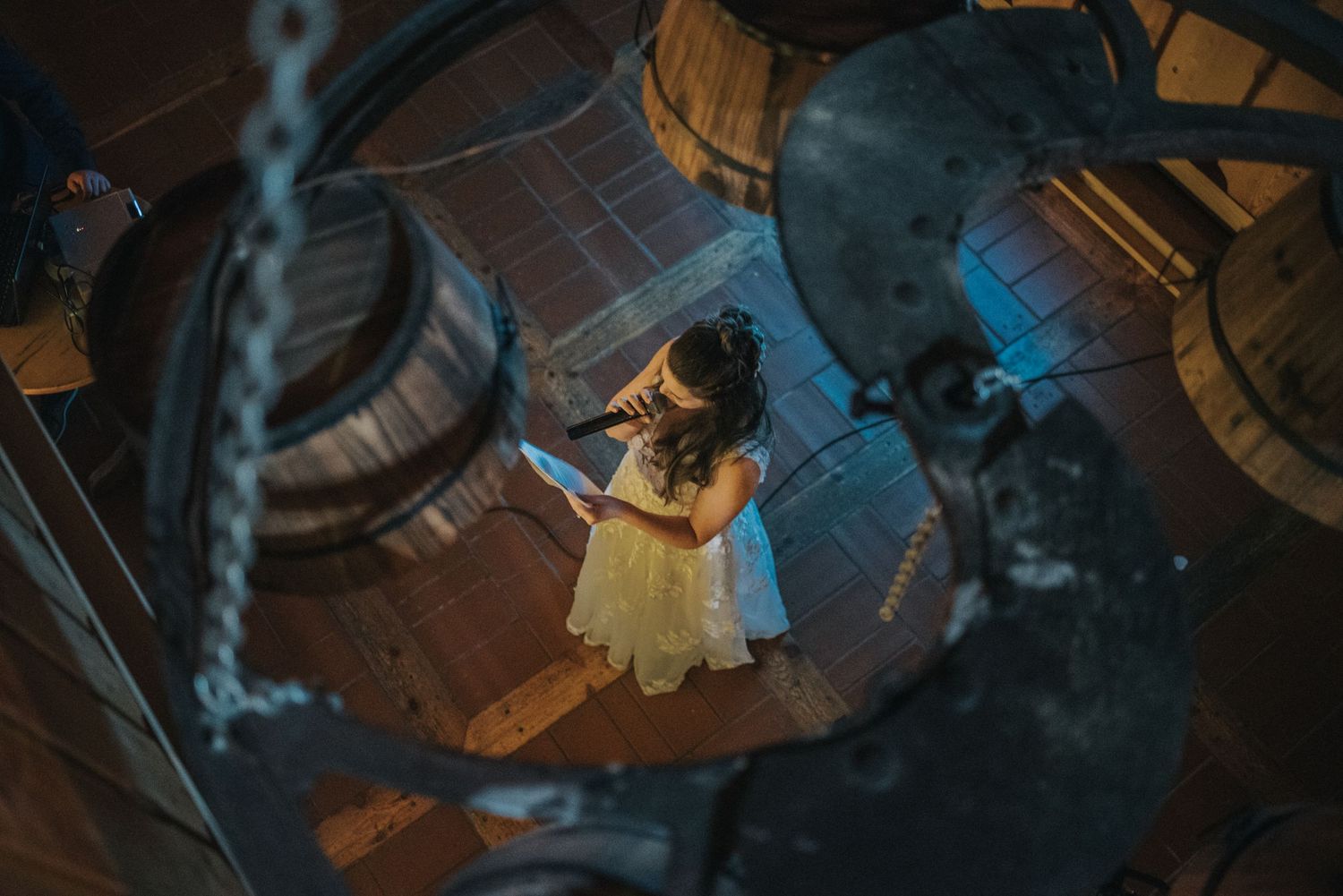 Artistic overhead shot of person in wedding dress standing alone in dramatic lighting.