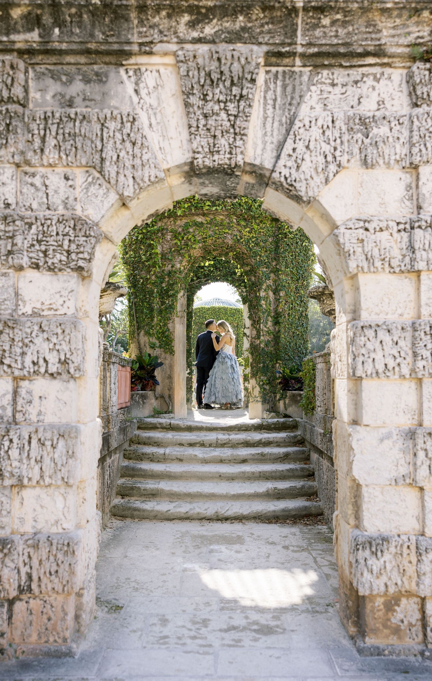 A romantic scene through stone archways with ivy and steps creating a stunning composition.