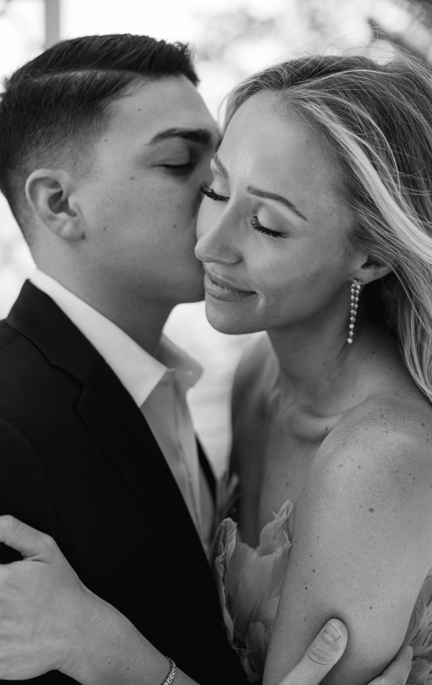 An intimate black and white portrait showing a tender romantic moment.