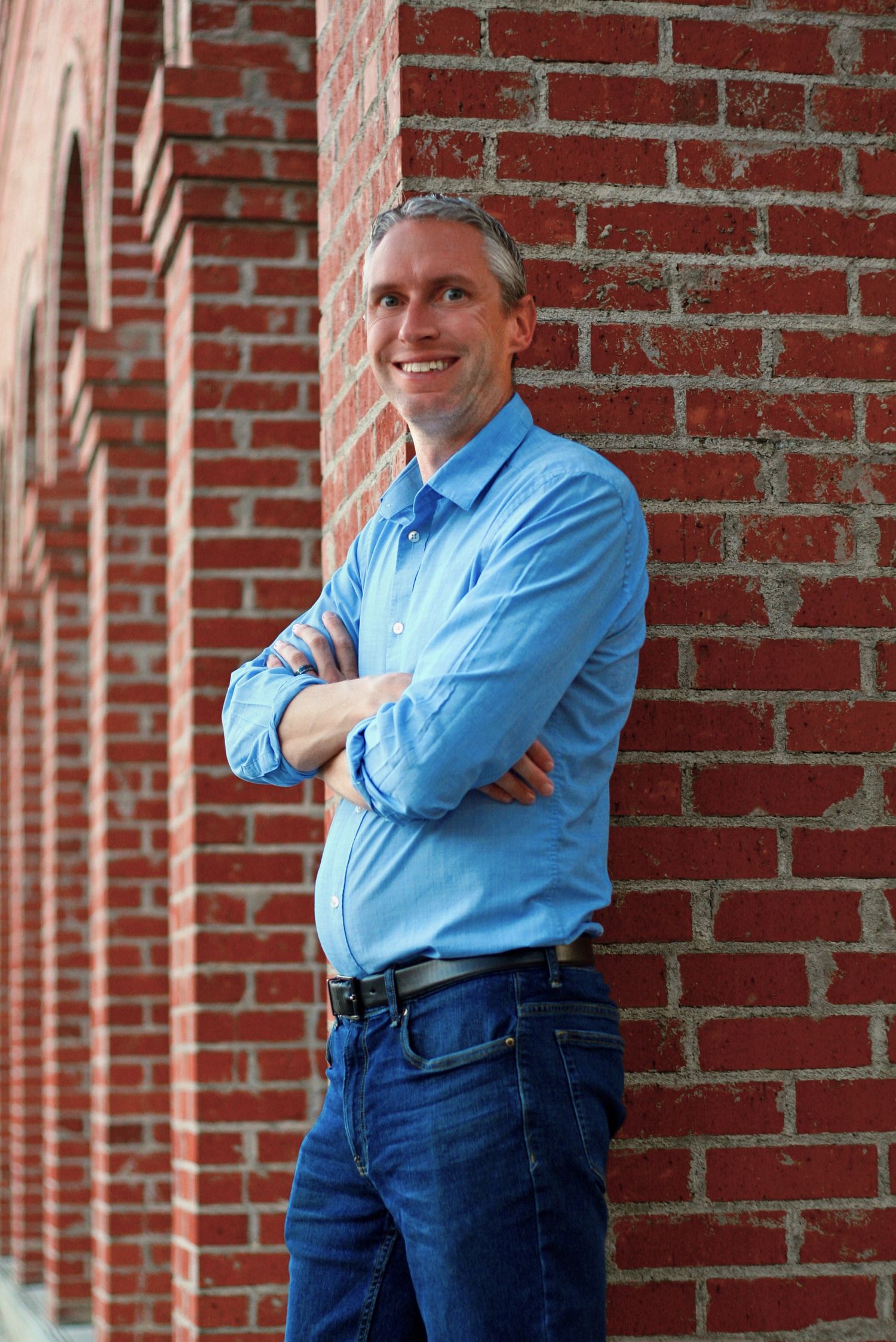 Multiple casual poses against red brick show a person wearing business casual attire.