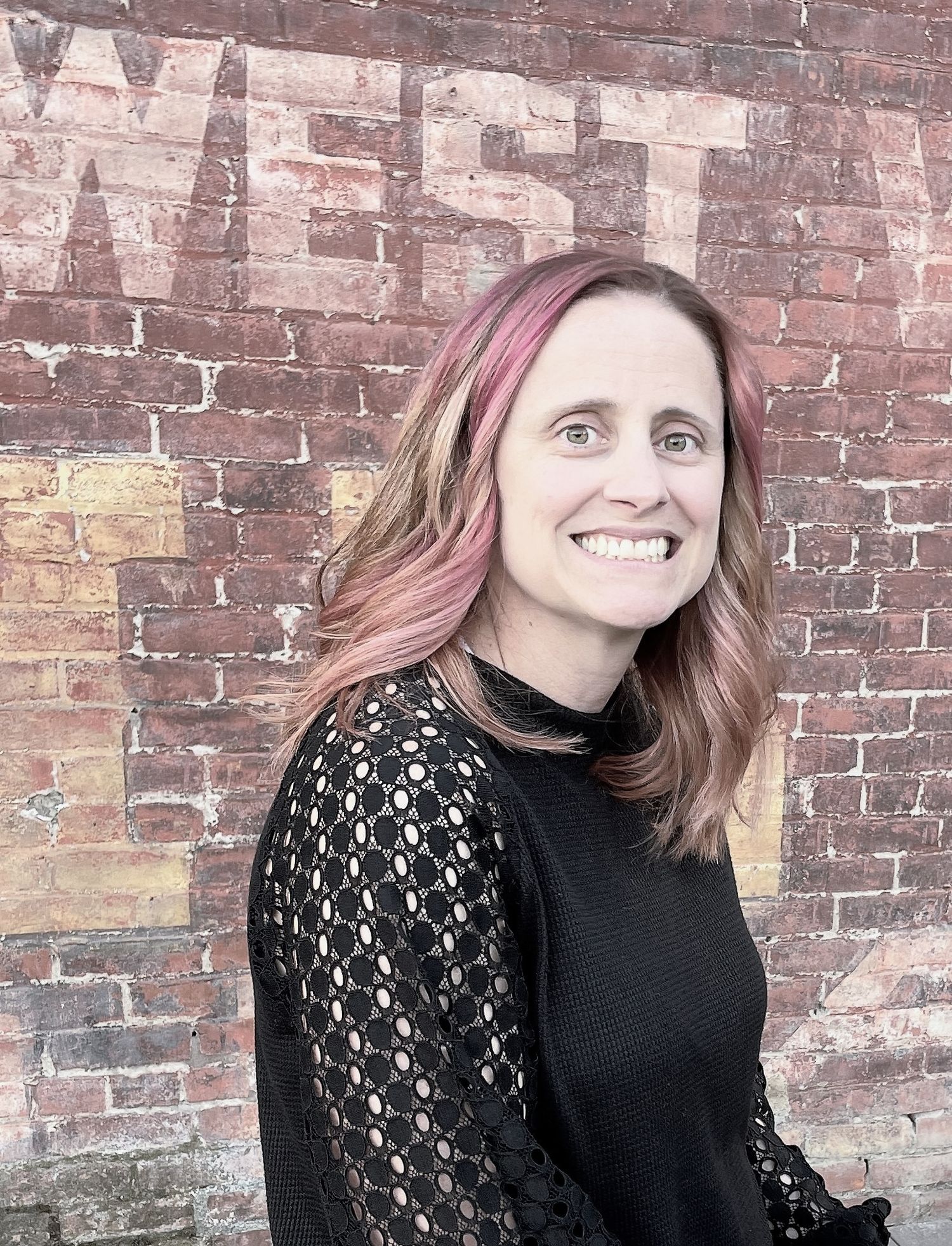 Multiple angles of someone posing against aged brick wearing a black top with patterned sleeves.