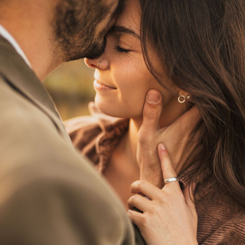 Closeup of a romantic intimate moment between a couple against a soft blurred background.
