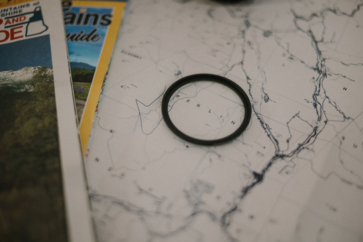Close-up of a black camera lens filter resting on a map.