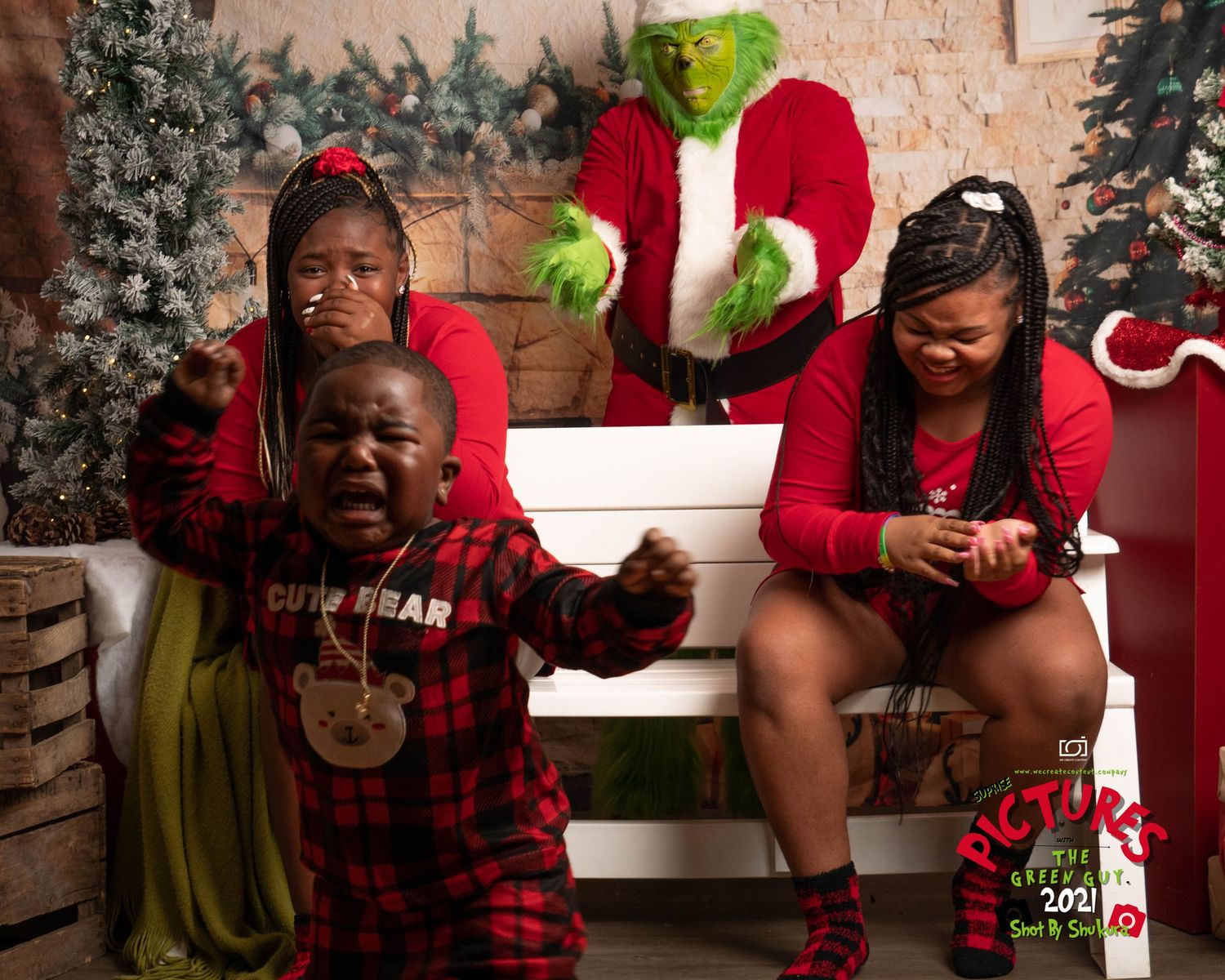 Family holiday photo with Grinch character and festive Christmas decor.