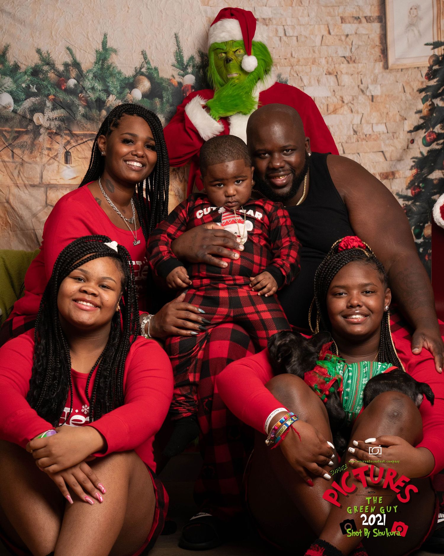 Family holiday portrait with Grinch character in festive Christmas setting.
