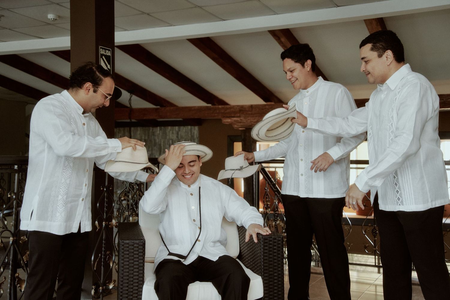Wedding party in white barongs performing celebratory ritual dance together.