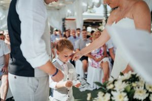 A touching moment during a wedding ceremony as a young ring bearer participates in the celebration.