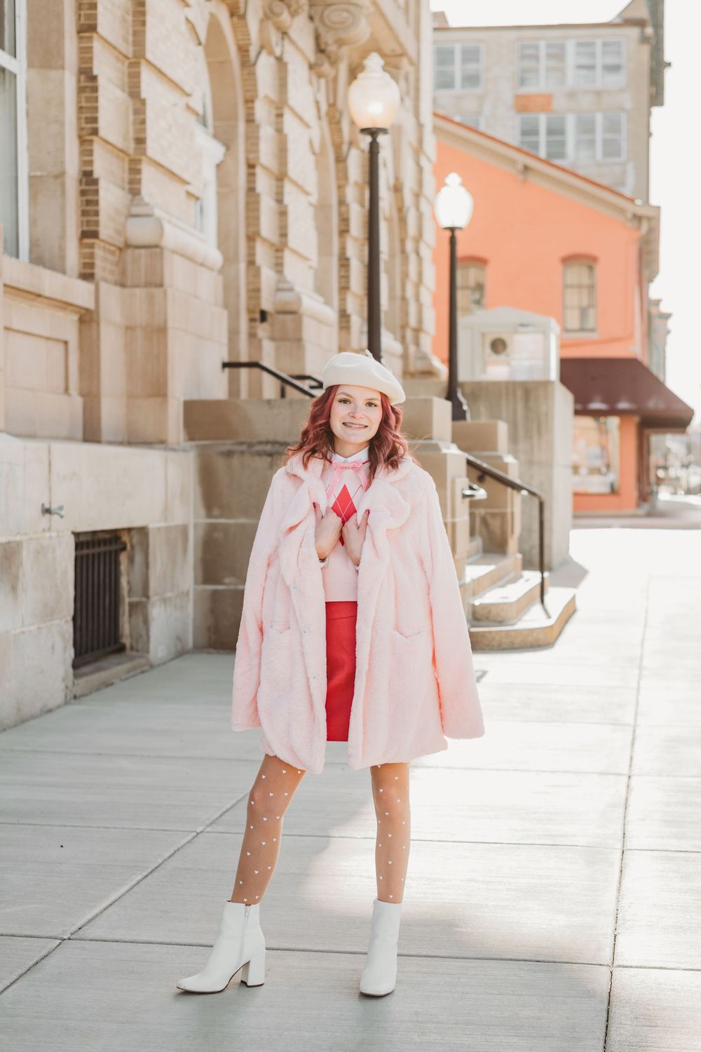 Fashion series featuring pink jacket and white boots against classic architecture.