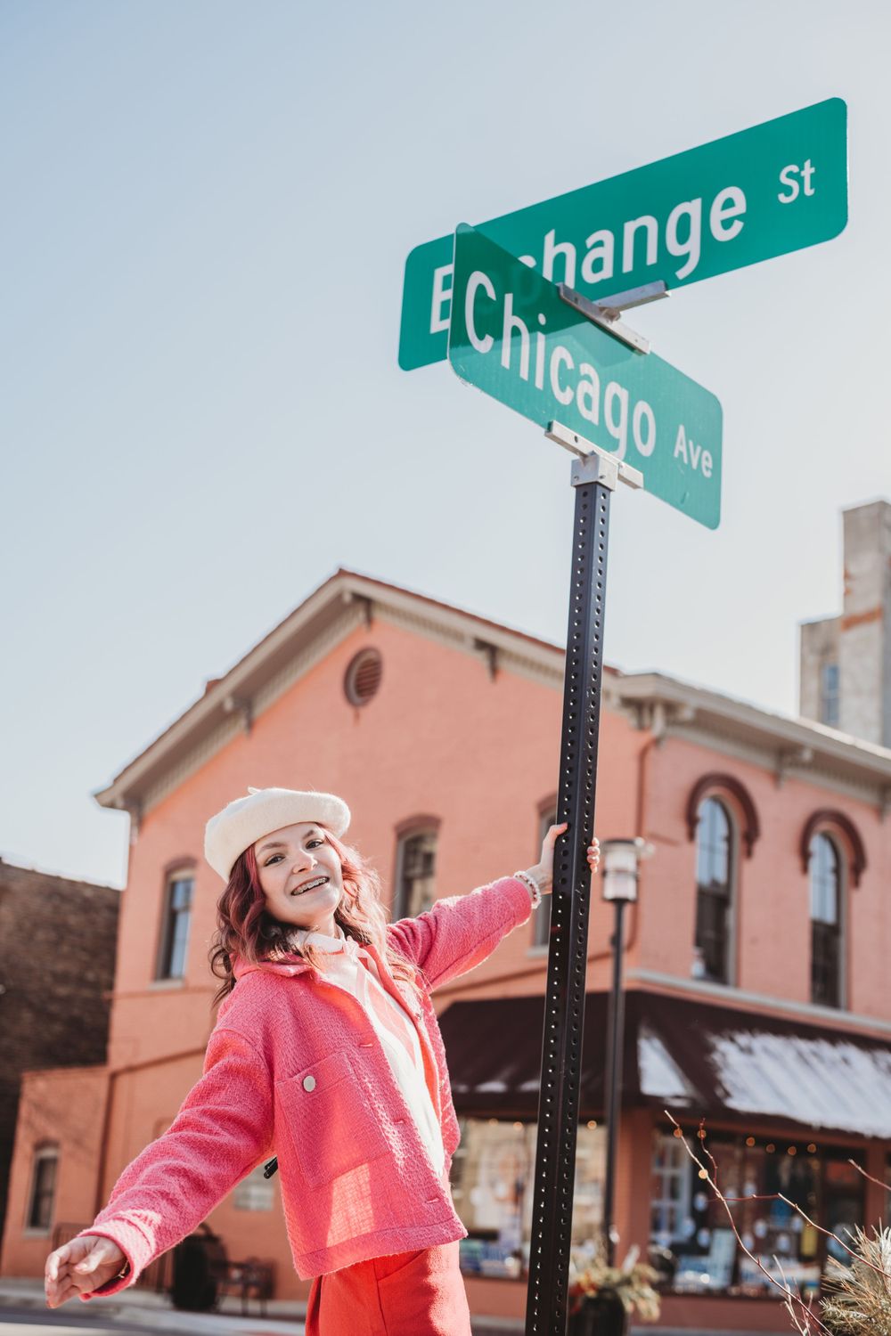 Street corner fashion shoot with pink coat near Exchange Street sign.