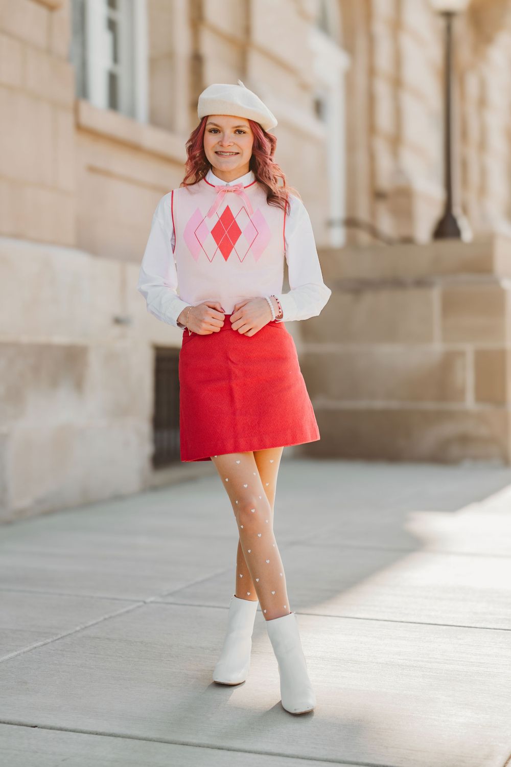 Vintage-inspired outfit with red dress and white collar against classic architecture.