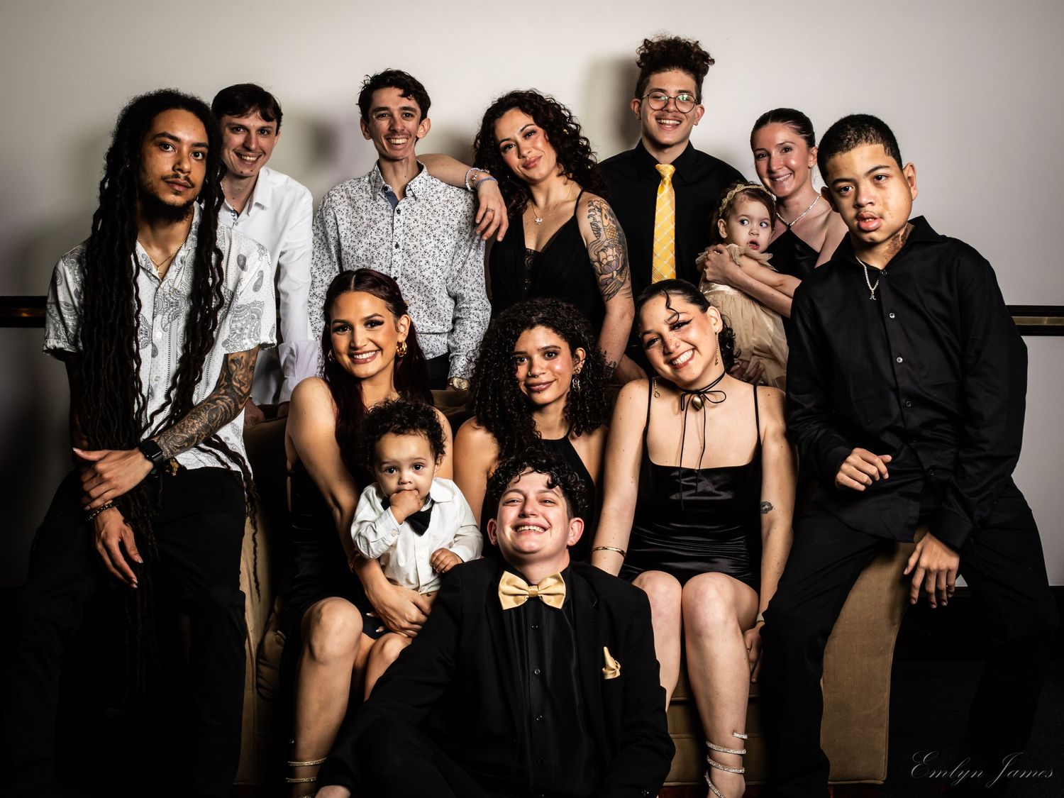 Professional studio portrait of a diverse theater group in formal attire against neutral background.