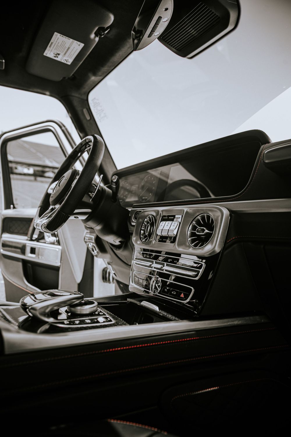 Interior view of luxury car dashboard and center console in black and white.
