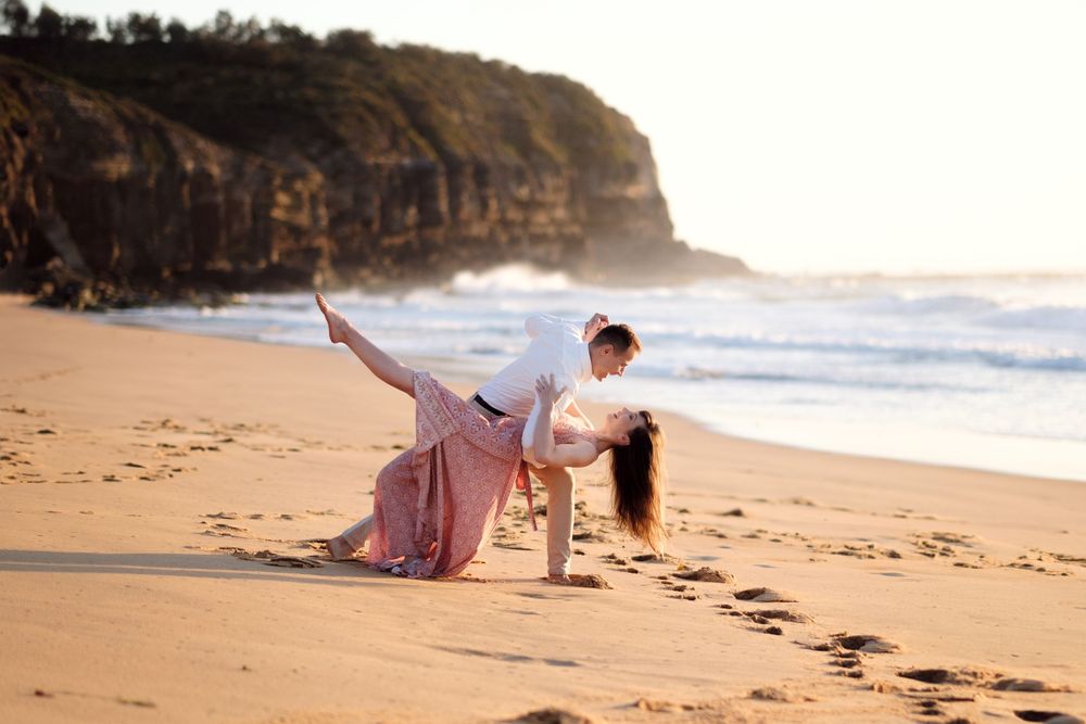 couple dancing during an engagement photo session at Turimetta beach
