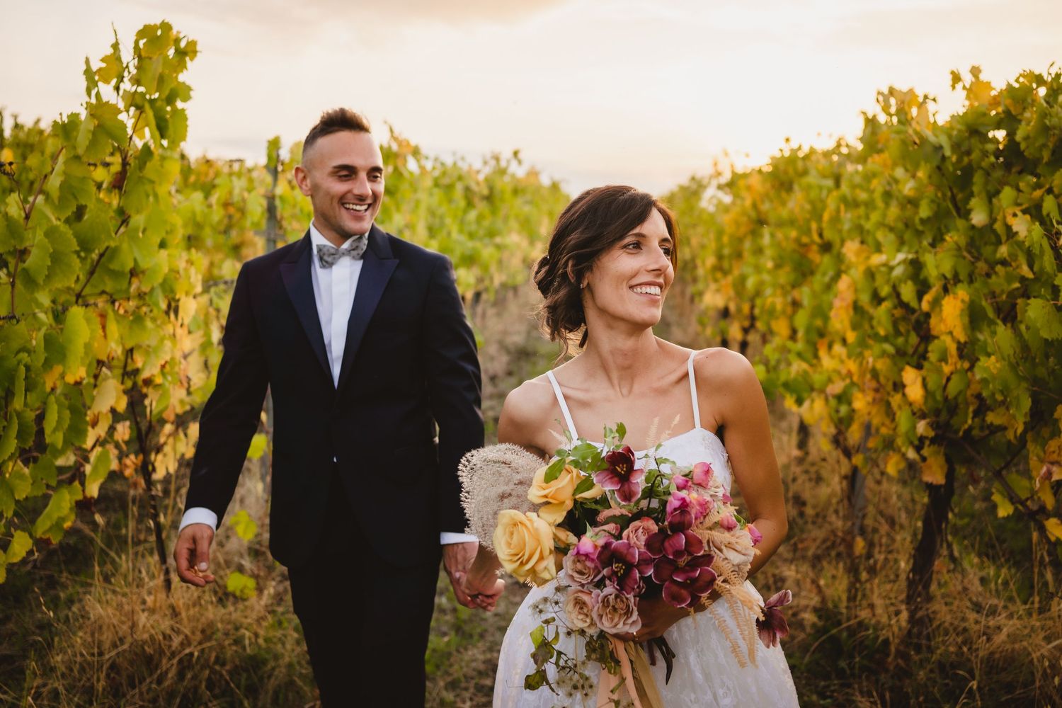 Elegant couple celebrates their wedding day in lush vineyard setting.