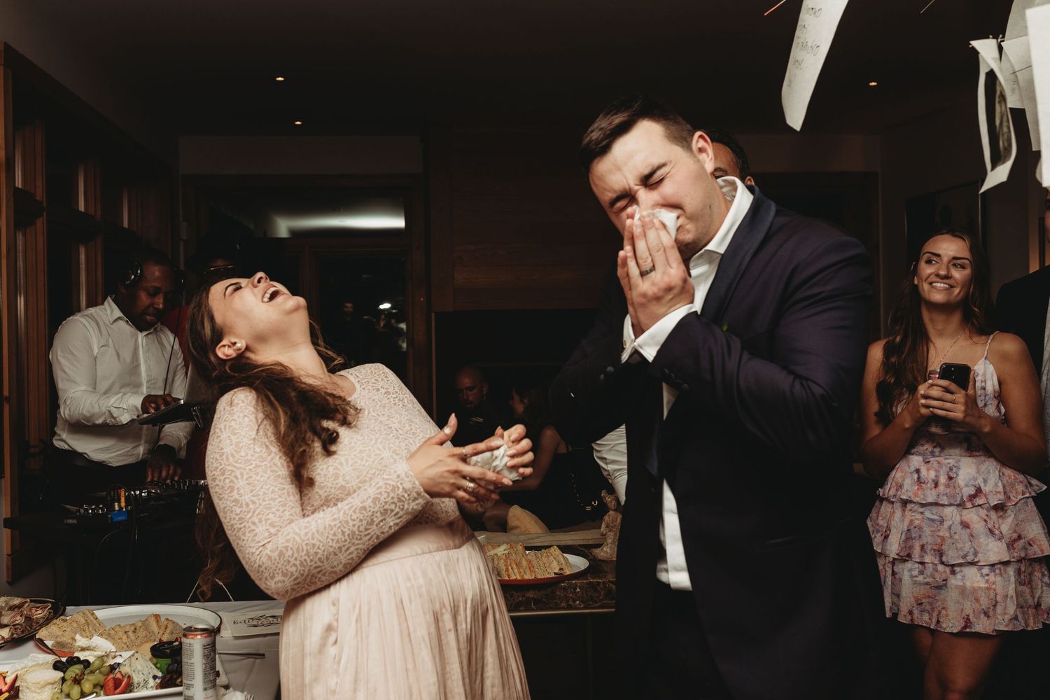 Couple enjoying a playful moment during their wedding cake-cutting ceremony.