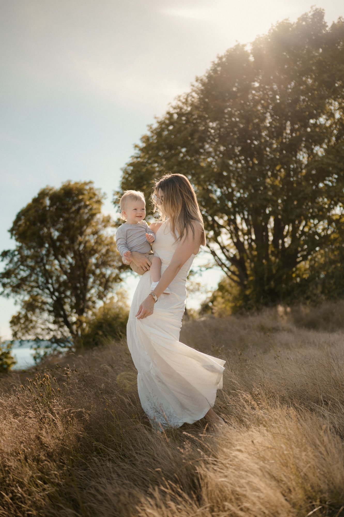 Motherhood photography session by San Marcos Photographer of mom holding baby dancing in a field