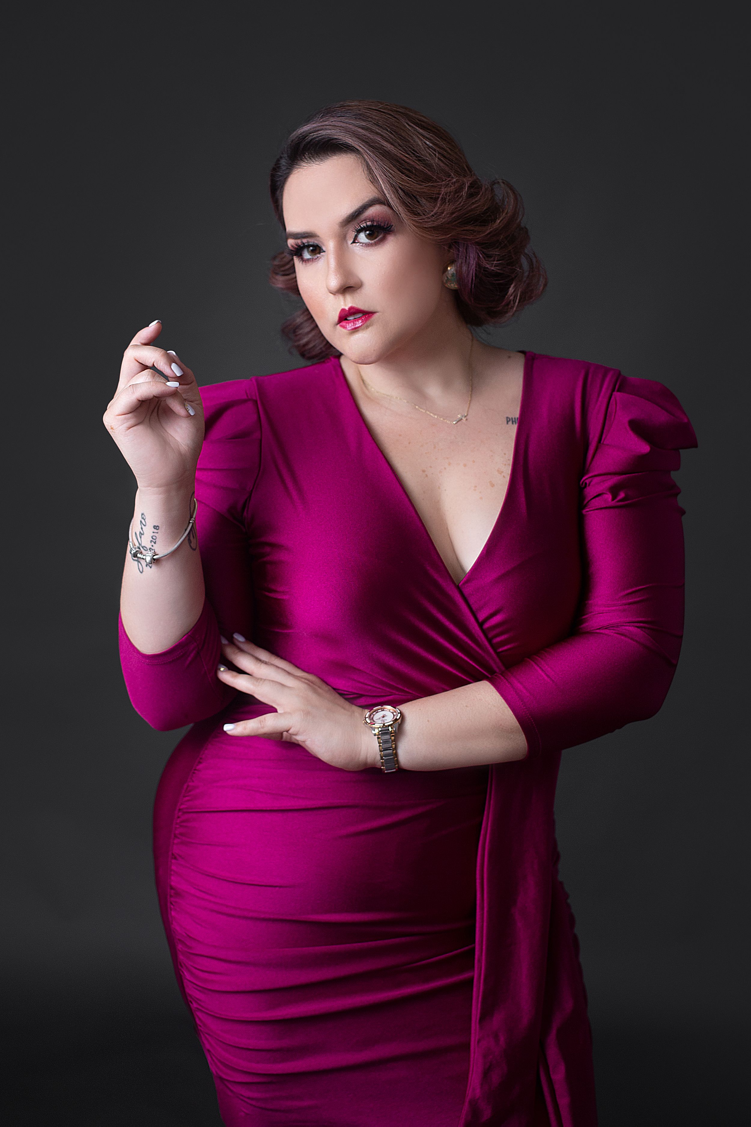 Professional portrait series in a deep magenta wrap dress against dark background.