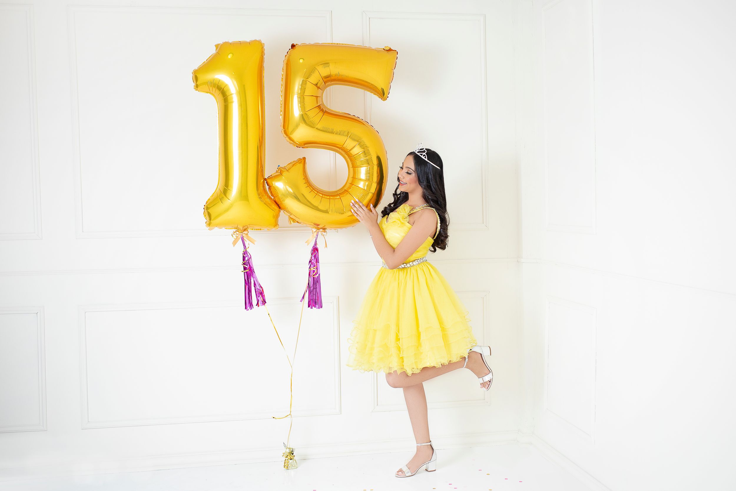 Yellow number 15 balloon photoshoot with dynamic poses against a white backdrop.