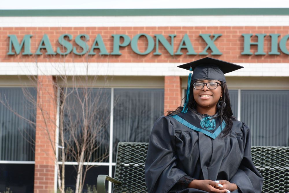 People in graduation regalia celebrating at a university campus.