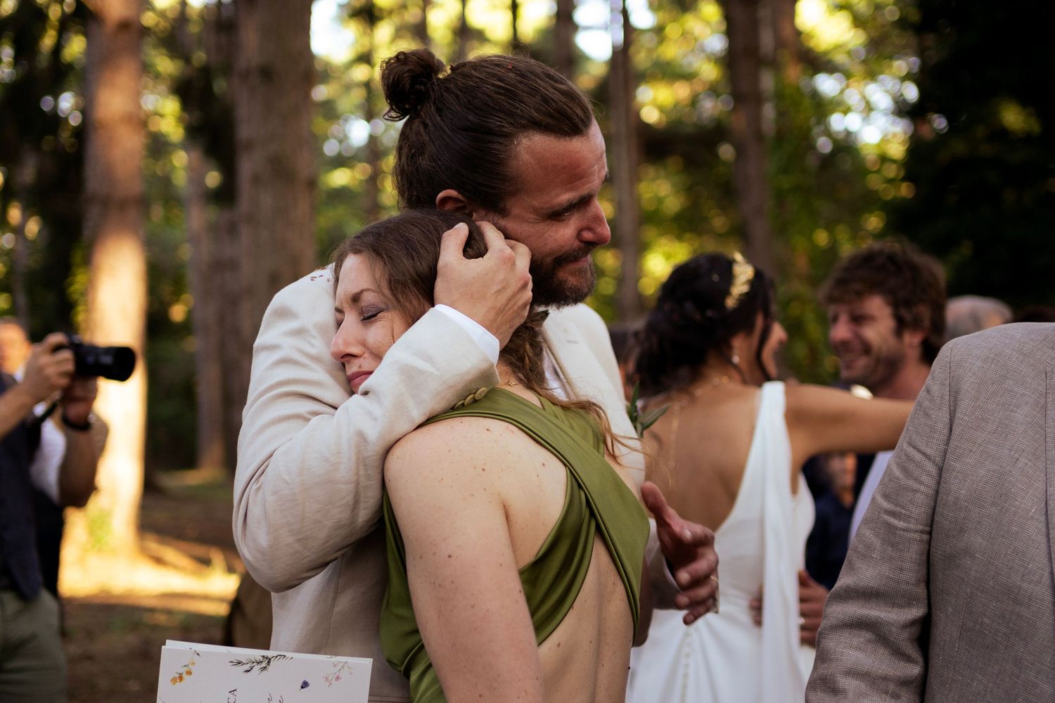 An emotional embrace during a woodland wedding reception.