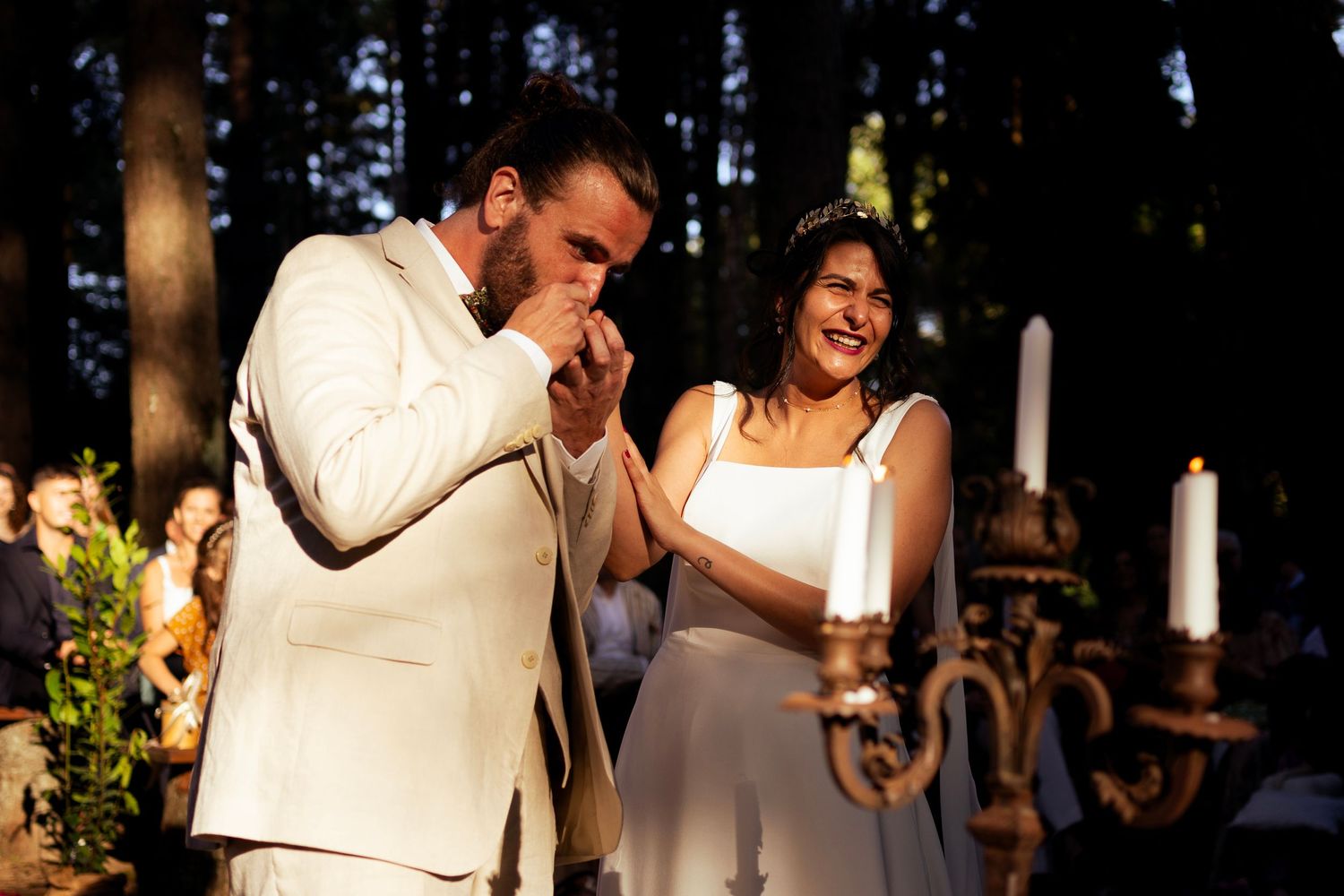 Emotional wedding ceremony moment in a wooded forest setting with candlelight.